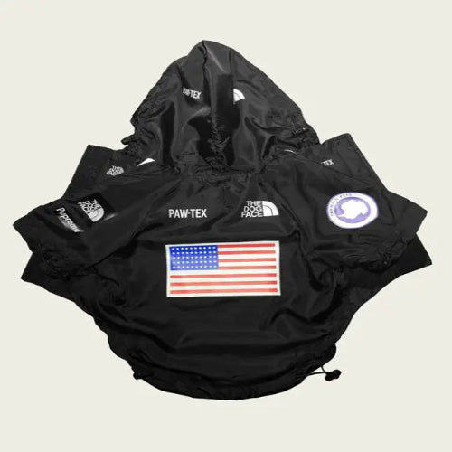 Black dog rain jacket with American flag design and 'Paw-tex' branding on a light gray background